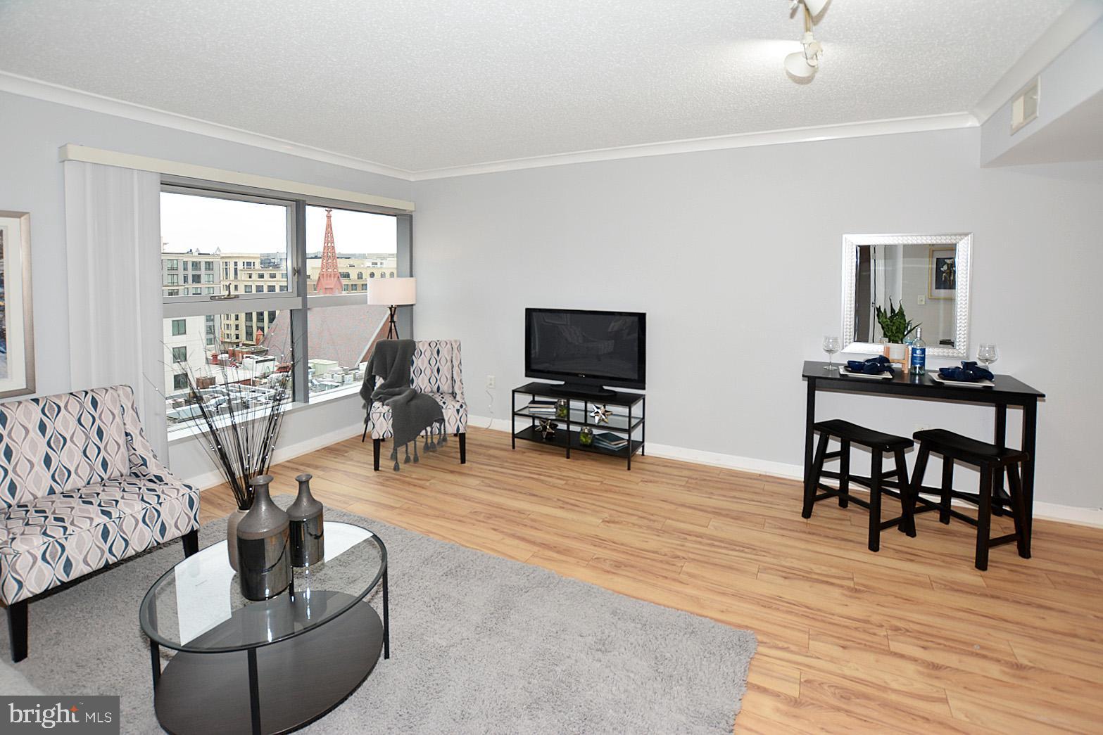 777 7th Street Northwest, Unit 1014 Washington, DC 20001 - Photo 8 of 43 a living room with furniture and a flat screen tv with wooden floor