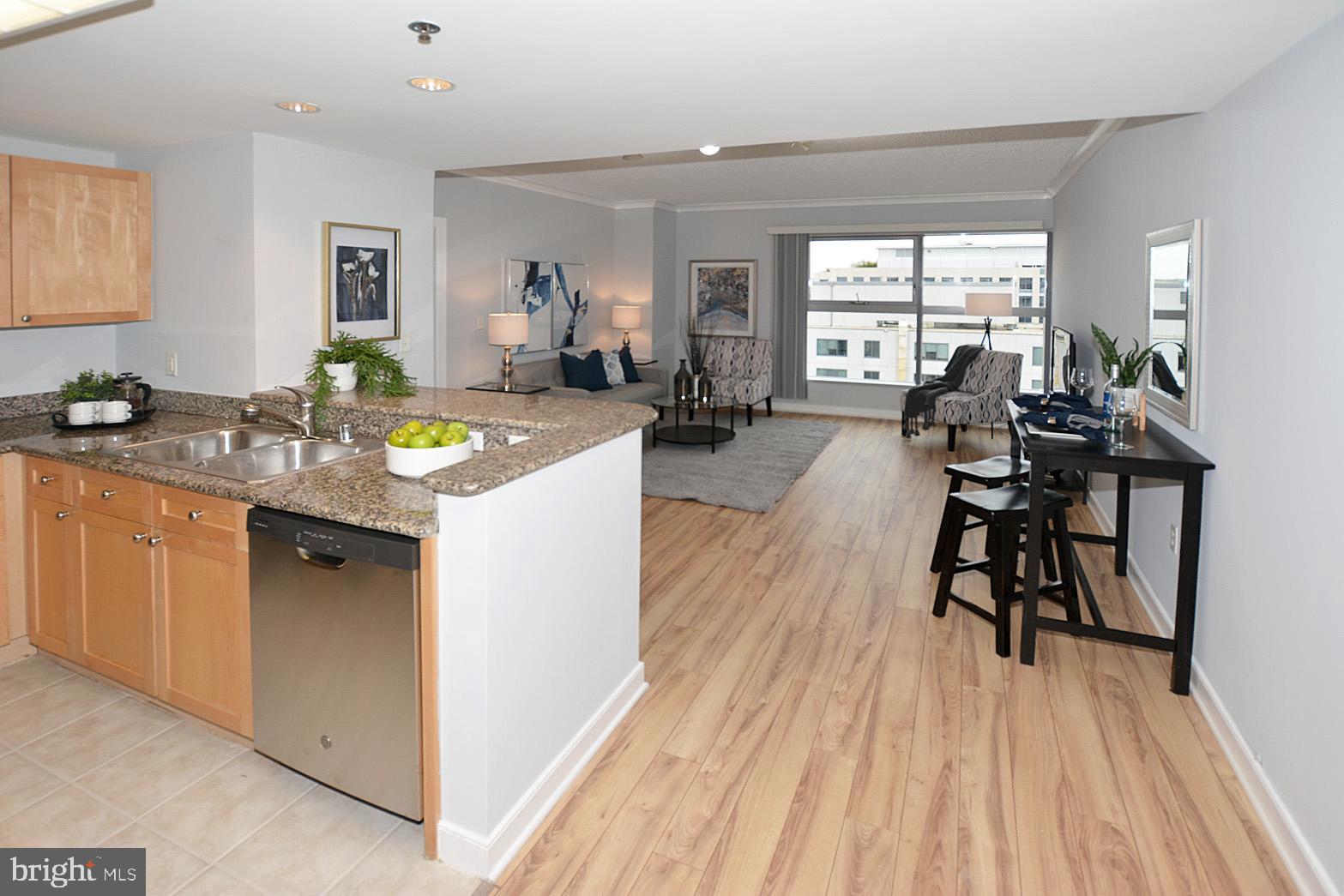 777 7th Street Northwest, Unit 1014 Washington, DC 20001 - Photo 10 of 43 a kitchen with wooden floors and white cabinets