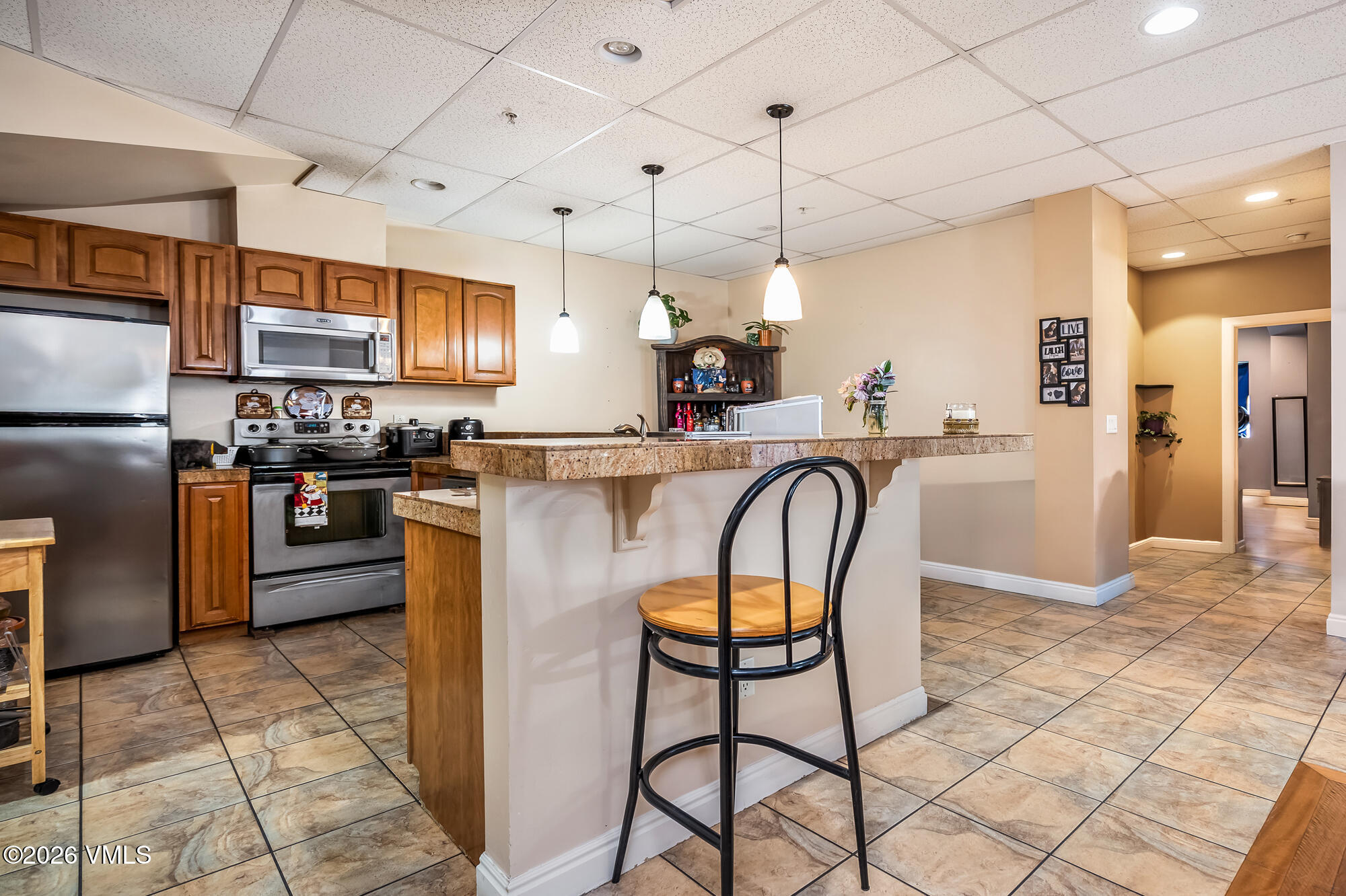 5 Murray Road, Unit B4 Edwards, CO 81632 - Photo 18 of 28 a kitchen with stainless steel appliances granite countertop a stove a refrigerator a oven a sink with a dining table and chairs
