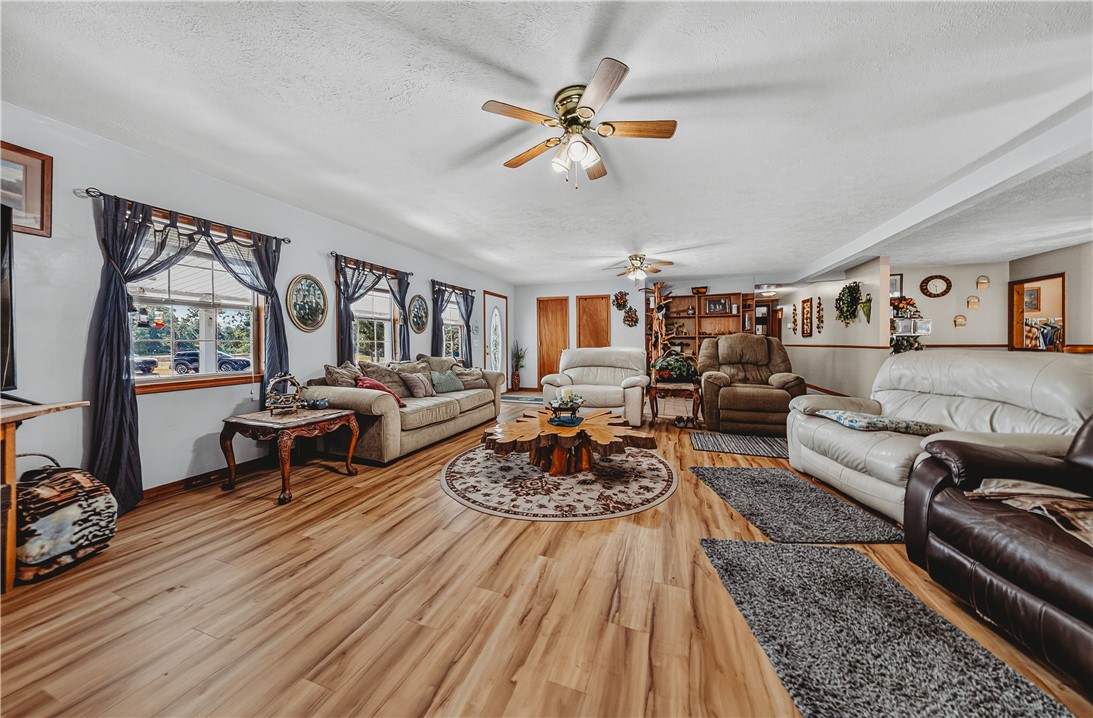 21587 West Hickory Flat Road Springdale, AR 72764 - Photo 11 of 45 Expansive living room with multiple seating areas, abundant natural light, wood flooring, and views toward the covered front porch.