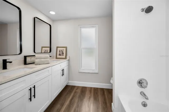 a spacious bathroom with 2 sink tub and a mirror
