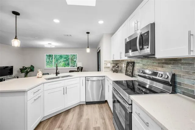 a kitchen with a sink stove and microwave