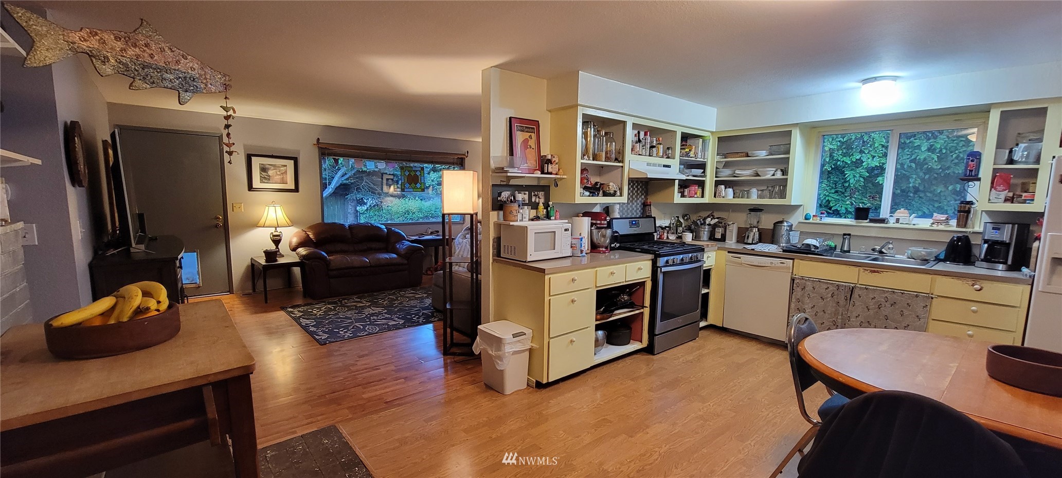 1224 Mission Road Everson, WA 98247 - Photo 9 of 30 a kitchen filled with a stove top oven a sink dishwasher a dining table and chairs with wooden floor