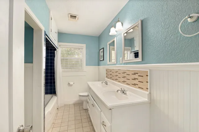 a bathroom with a sink a toilet and a mirror