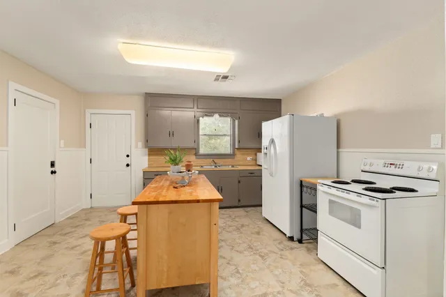 a kitchen with refrigerator and white cabinets