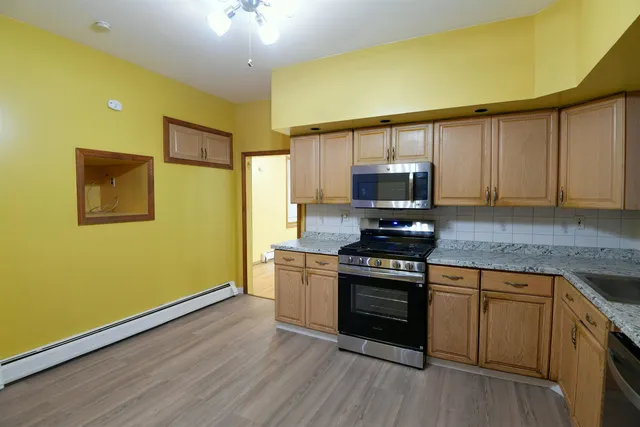 a kitchen with granite countertop wooden floors and stainless steel appliances