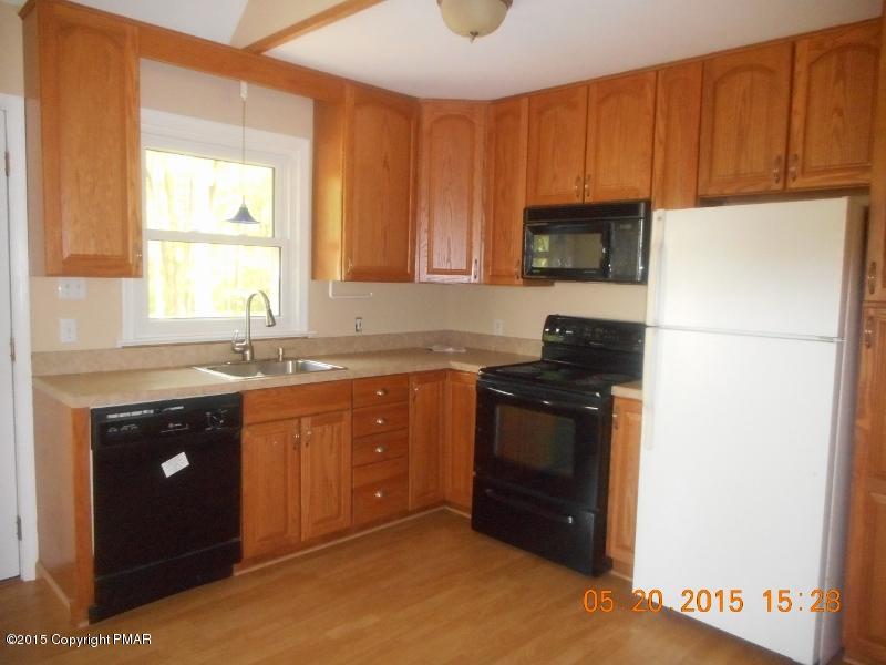 413 Devils Hole Road Cresco, PA 18326 - Photo 3 of 15 a kitchen with granite countertop a refrigerator stove and sink