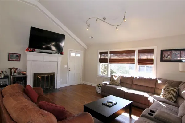 a living room with furniture a flat screen tv and a fireplace