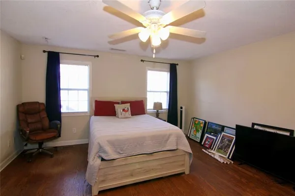 a bedroom with a bed and a chair with the potted plant