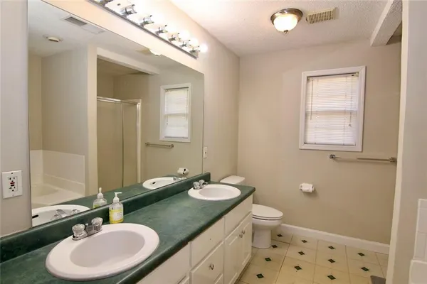 a bathroom with a granite countertop sink a mirror and a toilet