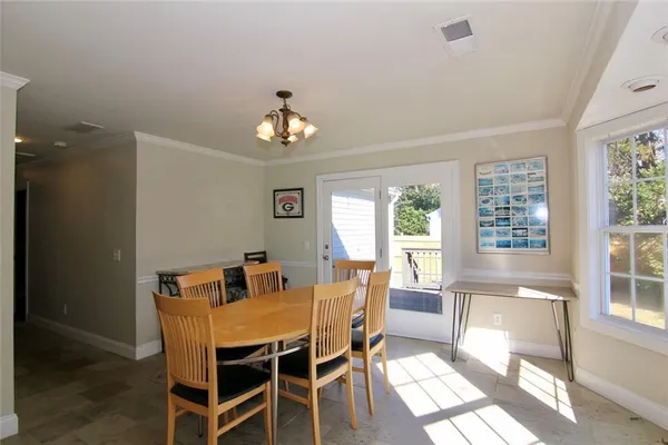 a view of a dining room with furniture a chandelier and wooden floor