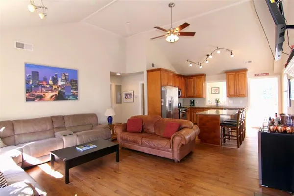 a living room with furniture kitchen view and a chandelier