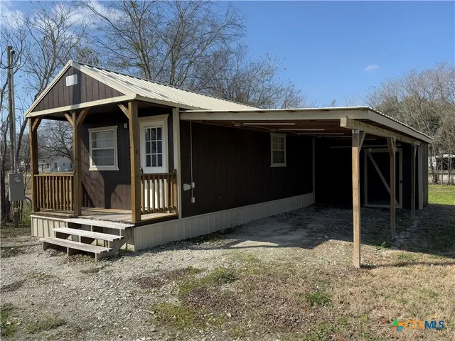 a backyard of a house with barbeque oven and table