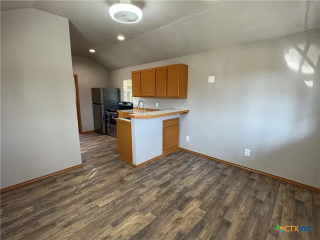 a view of a kitchen with a sink and a refrigerator