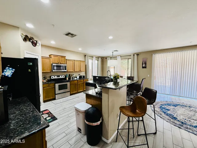 a open kitchen with stainless steel appliances granite countertop a stove refrigerator and cabinets