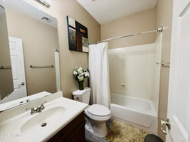 a bedroom with a bed window and a mirror