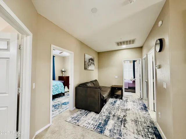 a spacious bedroom with a large bed and a chandelier