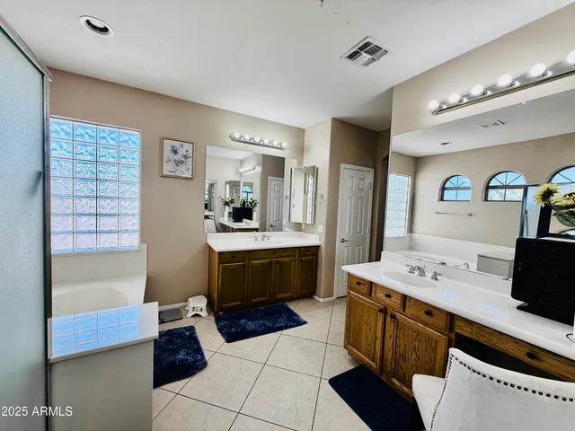 a bathroom with a tub sink and mirror