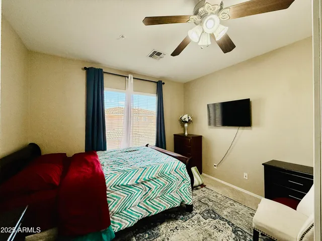 a bedroom with a bed and a flat tv screen on dresser