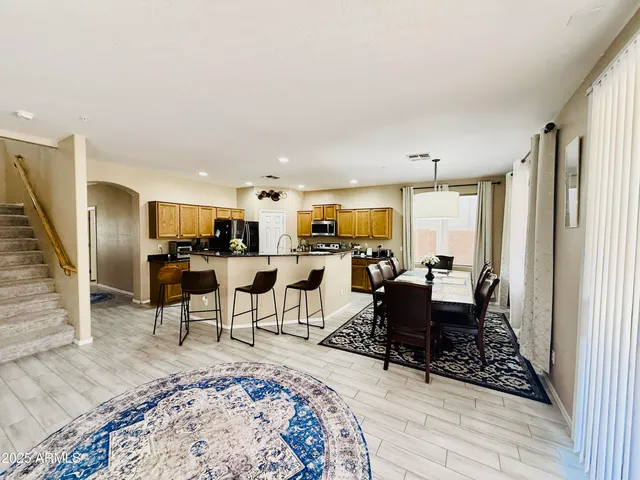 a living room with furniture a large window and stainless steel appliances