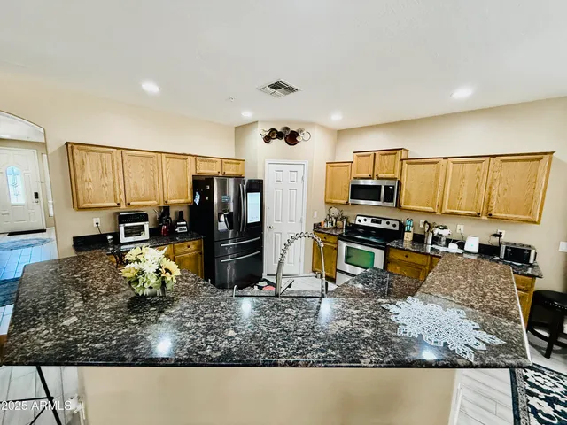 a kitchen with sink refrigerator and microwave
