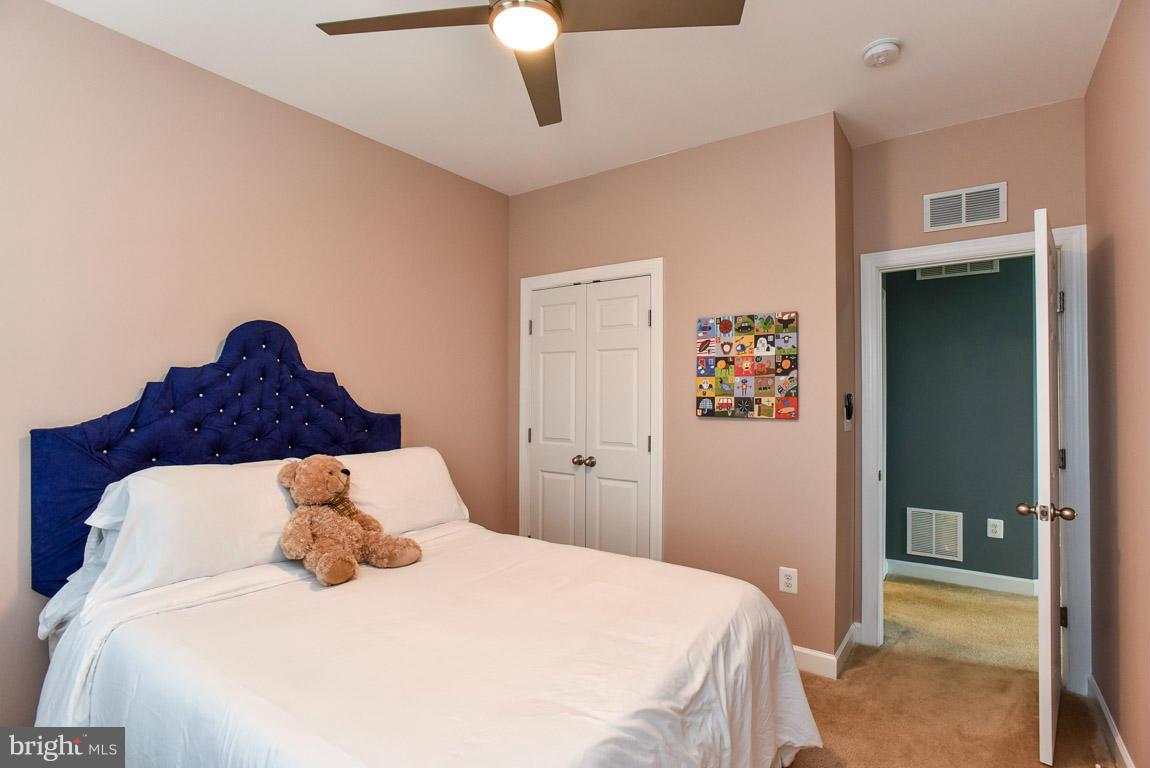 25175 Prairie Fire Square Aldie, VA 20105 - Photo 21 of 28 a bedroom with a bed and a chandelier