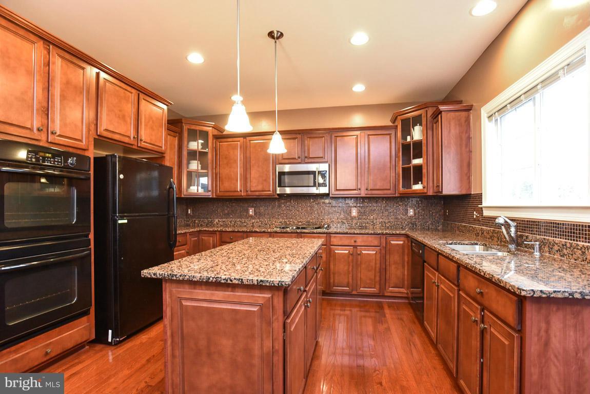 25175 Prairie Fire Square Aldie, VA 20105 - Photo 7 of 28 a kitchen with stainless steel appliances granite countertop a sink a stove and a refrigerator
