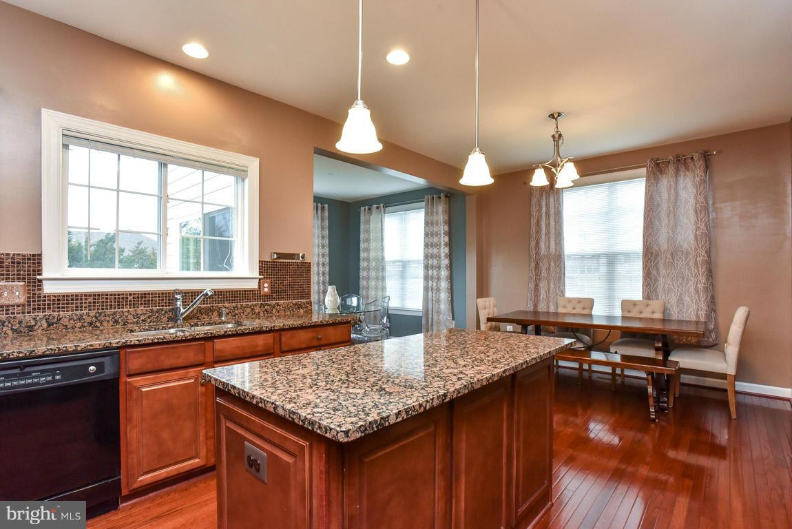25175 Prairie Fire Square Aldie, VA 20105 - Photo 10 of 28 a kitchen with a stove a sink and a wooden cabinets
