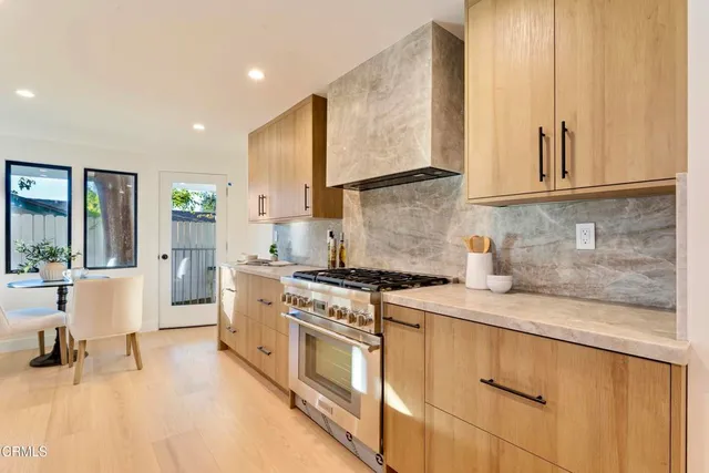 a kitchen with stainless steel appliances granite countertop a stove a sink and a refrigerator