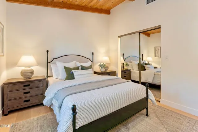 a bedroom with bed and a large mirror