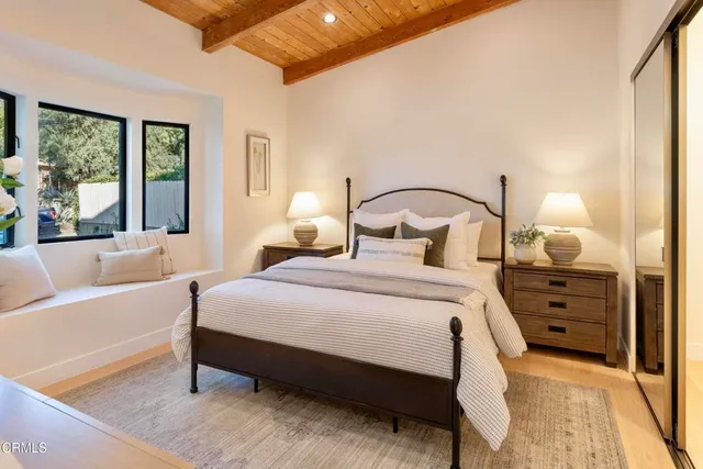 a bedroom with a large bed and windows