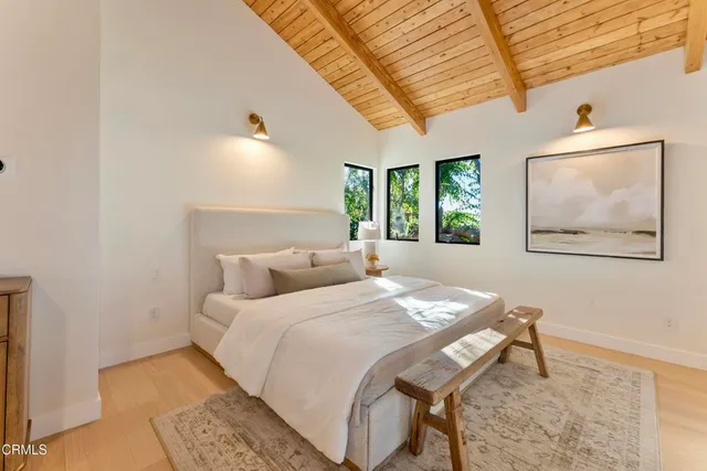 a bedroom with a bed and a painting on the wall