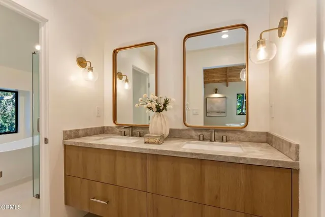 a bathroom with a granite countertop sink and a mirror