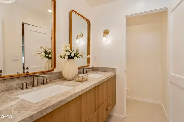 a bathroom with a granite countertop sink and a mirror
