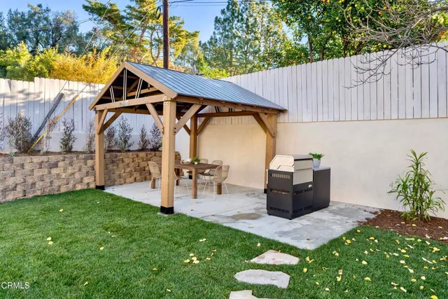 a view of a patio with table and chairs with wooden fence and plants