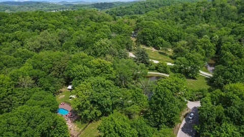 an aerial view of residential houses with outdoor space and trees