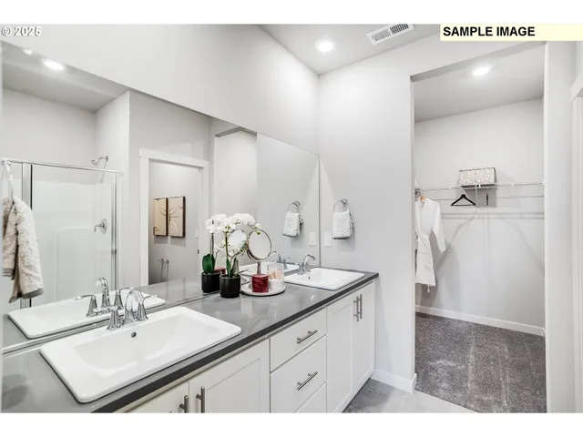 a bathroom with a double vanity sink a mirror and shower