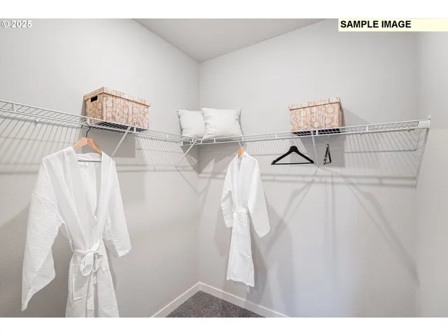 a walk in closet with wooden floor