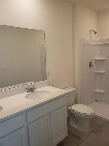 a bathroom with a granite countertop sink a toilet and a mirror