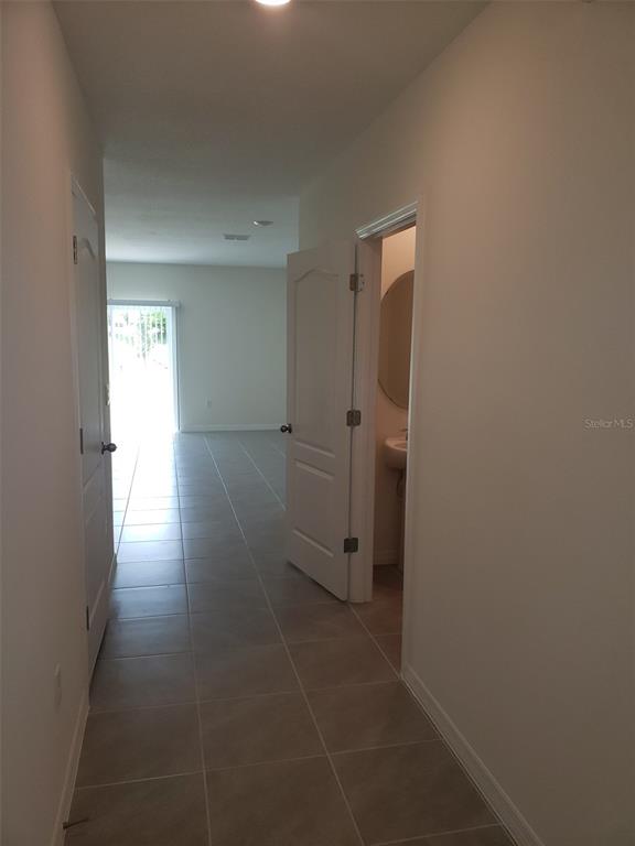 1670 Rock Elm Road Davenport, FL 33837 - Photo 4 of 28 a view of a hallway with wooden floor and a bathroom