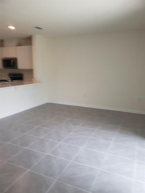 1670 Rock Elm Road Davenport, FL 33837 - Photo 7 of 28 a view of kitchen and empty room with wooden floor