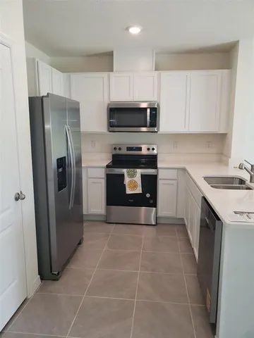 a kitchen with stainless steel appliances a refrigerator sink and microwave
