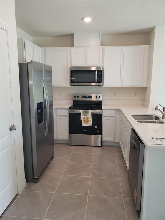 1670 Rock Elm Road Davenport, FL 33837 - Photo 8 of 28 a kitchen with stainless steel appliances granite countertop a refrigerator a sink a stove a microwave and island