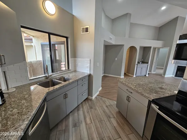 a kitchen with stainless steel appliances granite countertop a stove refrigerator sink and microwave