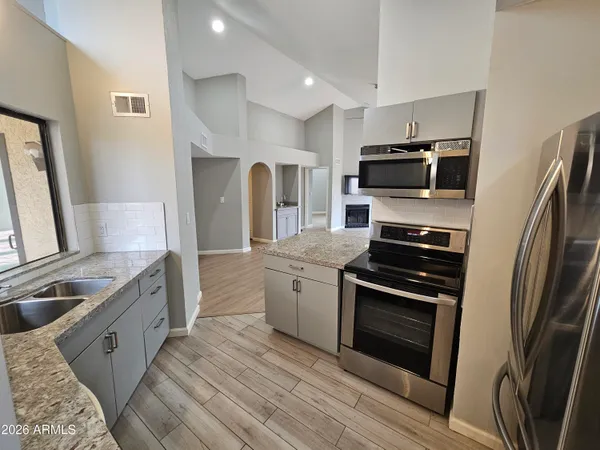 a kitchen with sink stove and refrigerator