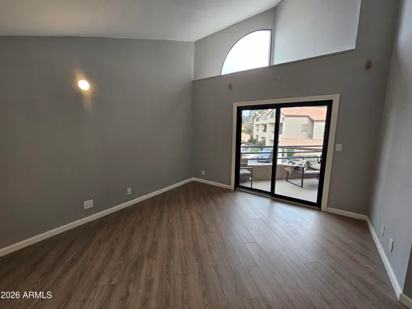 a view of a hallway with wooden floor and cabinet