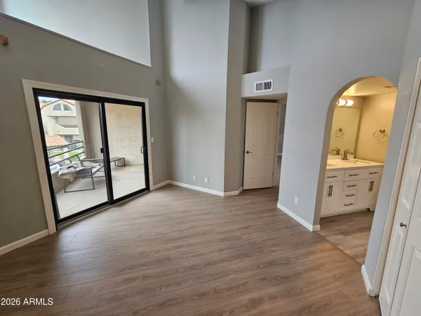 an empty room with wooden floor and windows
