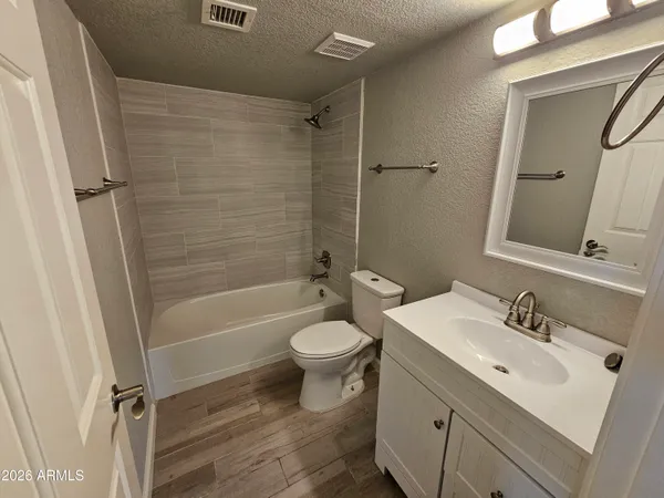 a view of an empty room with wooden floor and closet