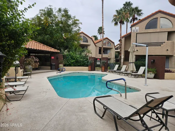 a patio with glass top table and chairs