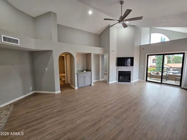 a view of empty room with a fireplace and wooden floor